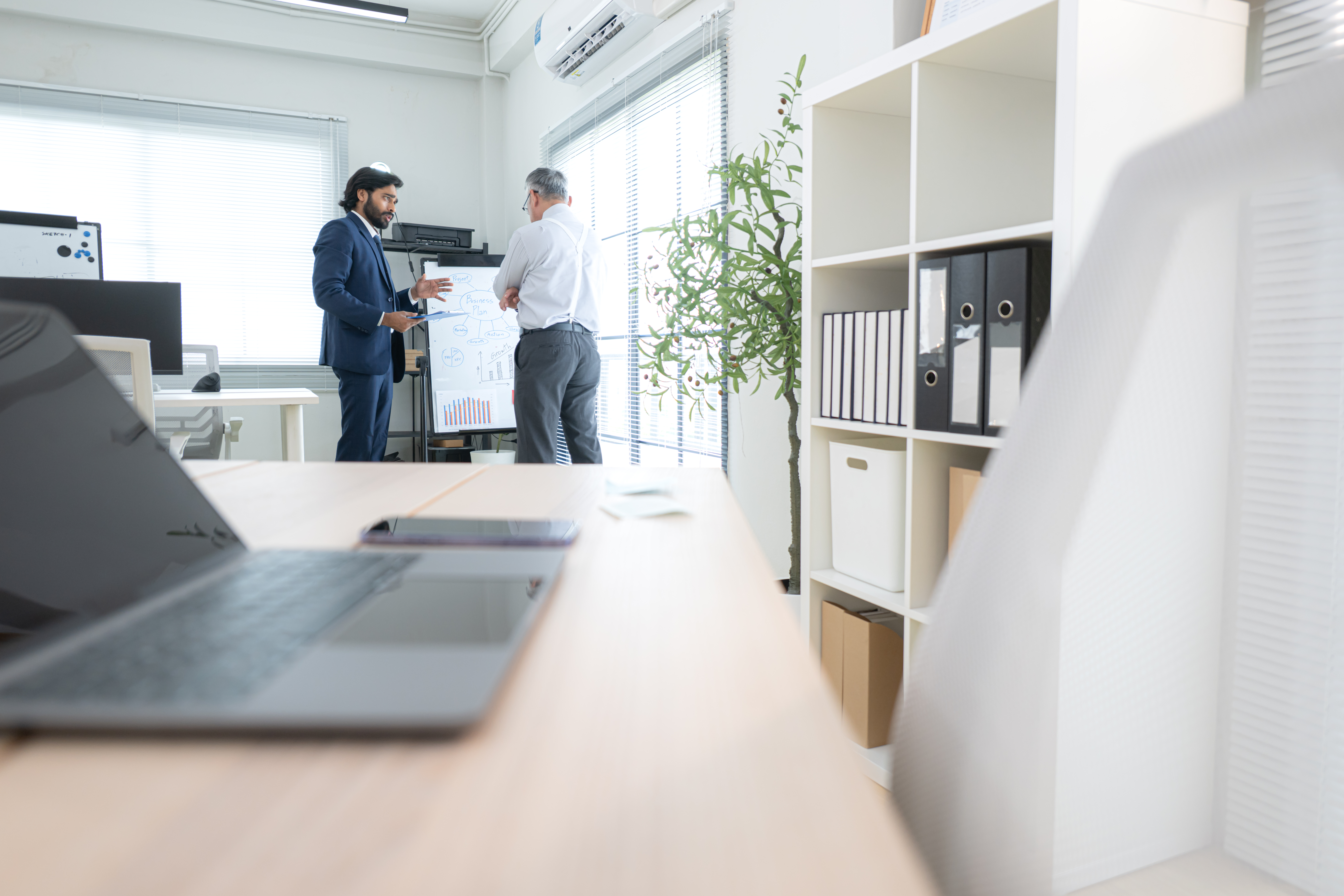 In a contemporary office, two senior executives with a mission t In a contemporary office, two senior executives with a mission to brainstorm and monitor the progress of a business project